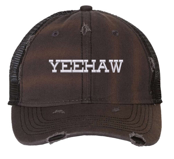 Image shows a distressed trucker hat with "Yeehaw" embroidered on the front. The hat features a mesh back and snapback closure.